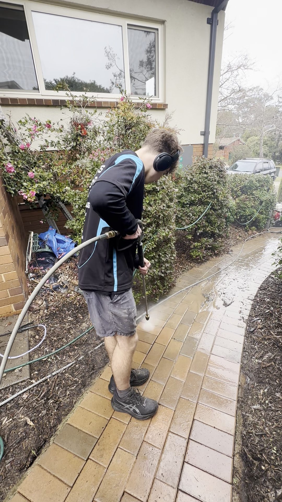 Connor's Cleaning technician pressure cleaning a brick paver path in a Canberra suburb