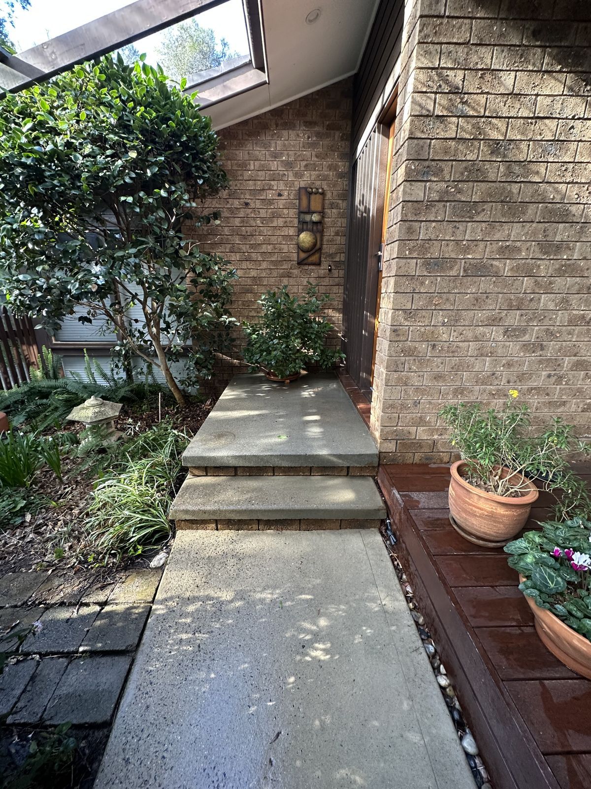 Pressure cleaned concrete walkway beside a Canberra home