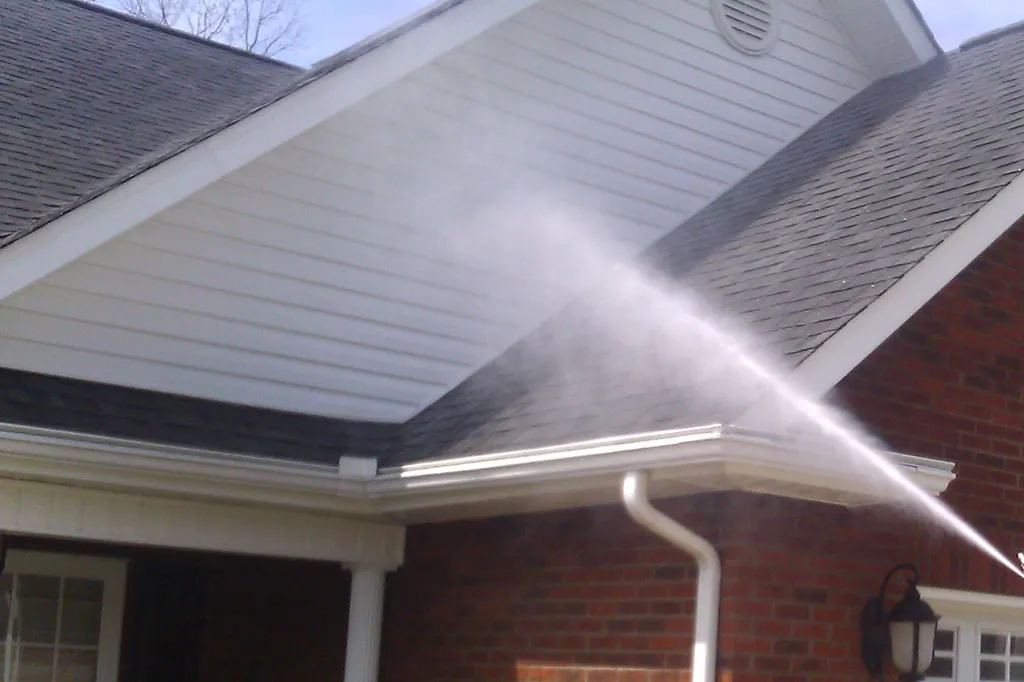 Soft washing spray applied to house siding and eaves in Canberra